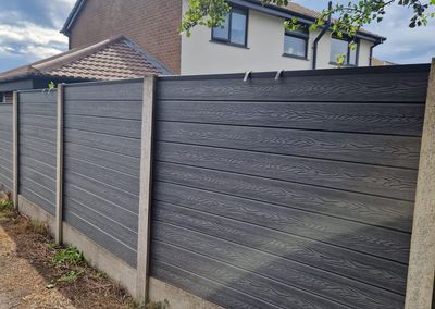 Grey composite fencing installed beside a house