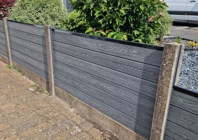 Grey composite fencing installed beside a house