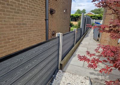 Grey composite fencing installed beside a house