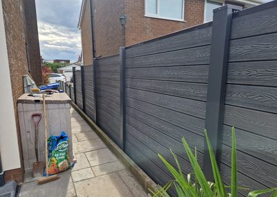 Grey composite fencing installed beside a house