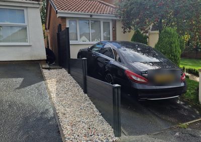 Black composite fencing beside a driveway