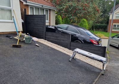 Black composite fencing beside a driveway