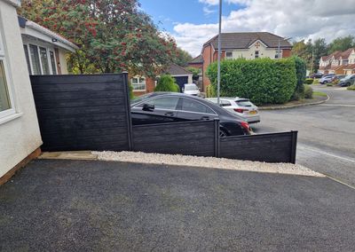 Black composite fencing beside a driveway