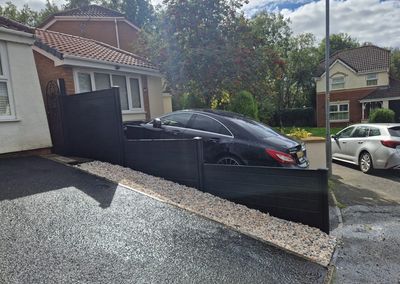 Black composite fencing beside a driveway
