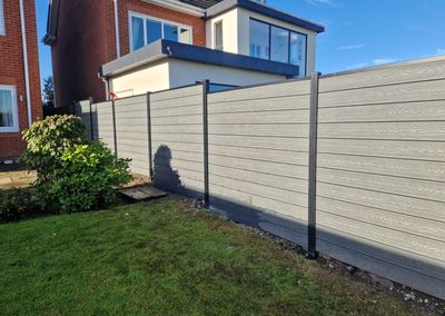 Grey composite fencing around a garden and patio