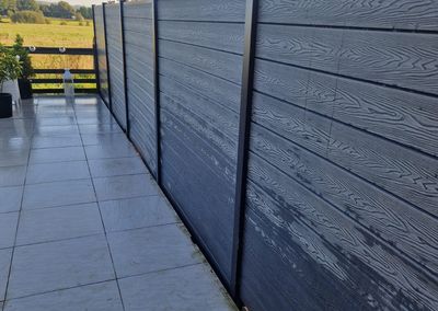 Grey composite fencing around a garden and patio