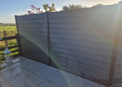 Dark grey composite fence panels on a patio