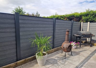 Grey composite fencing around a patio seating area
