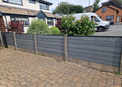 Grey composite fence on a front garden wall