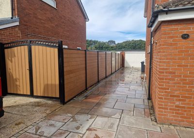 Oak effect composite fence and gate beside a house