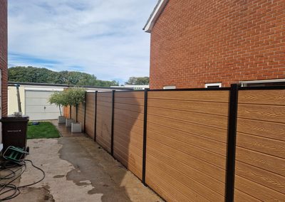 Oak effect composite fencing along a side path